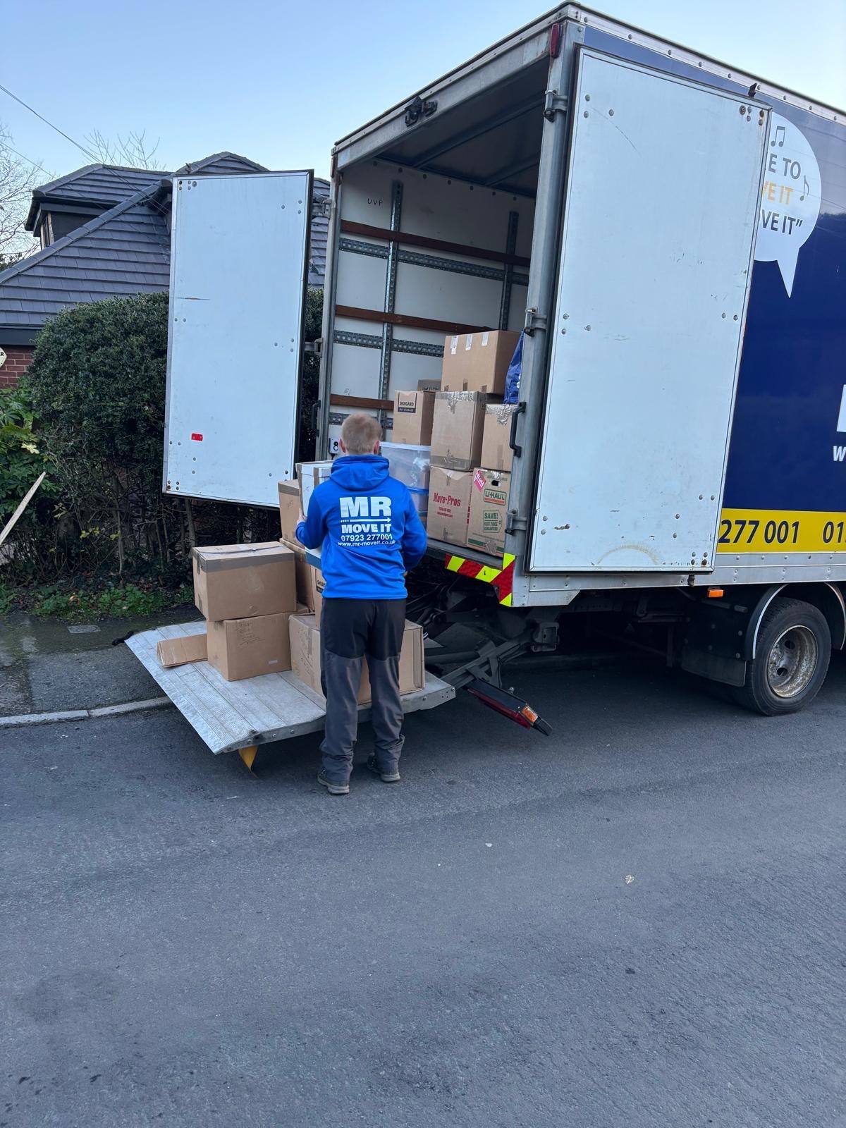 Mr Move It team member loading boxes onto the removals van