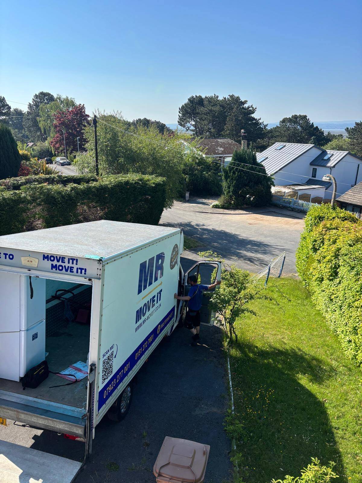 Mr Move It Luton van with the tail-lift down on a sloped driveway