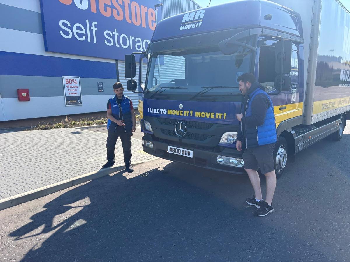 Mr Move It crew member beside the removals lorry at a storage facility
