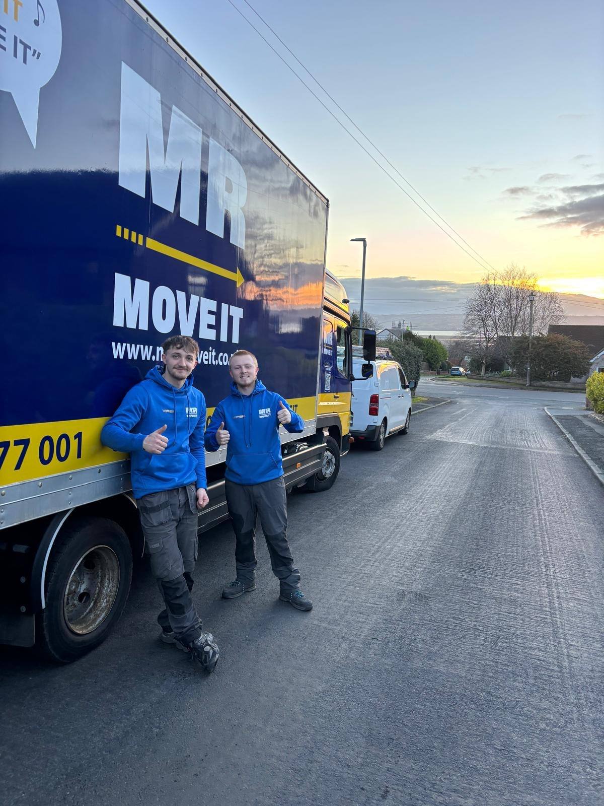 Two Mr Move It crew members in branded uniform beside the removals lorry at the end of a job