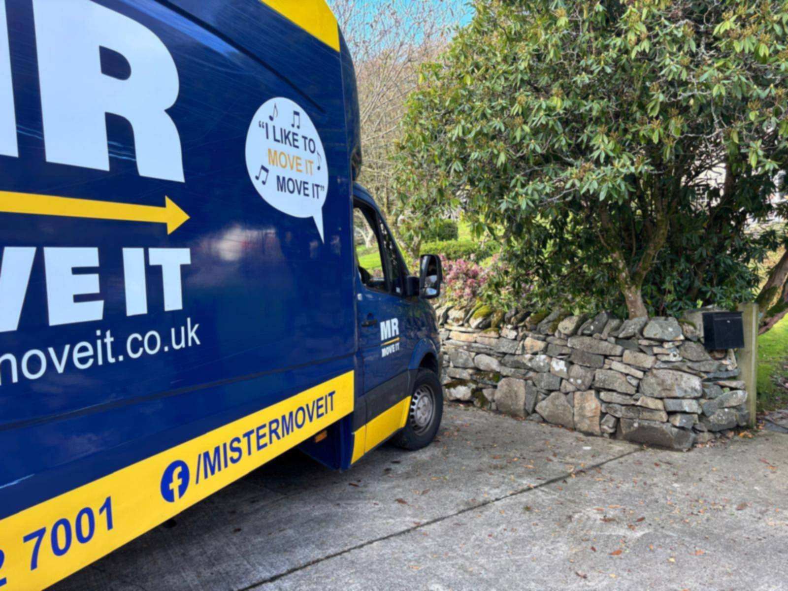 Mr Move It Luton removals van with full livery parked on a sunny residential street